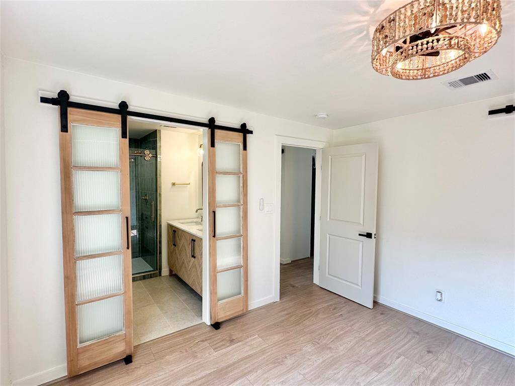 Primary bedroom with gorgeous doors leading into en suite.