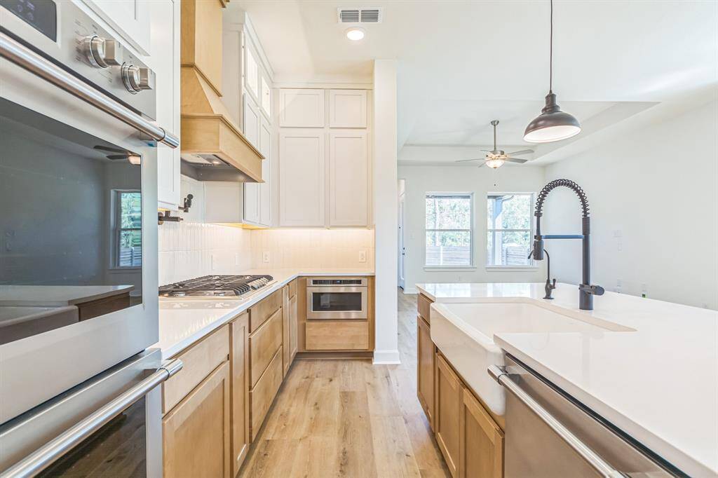 lots of cabinets with lighted glass door cabinets on top