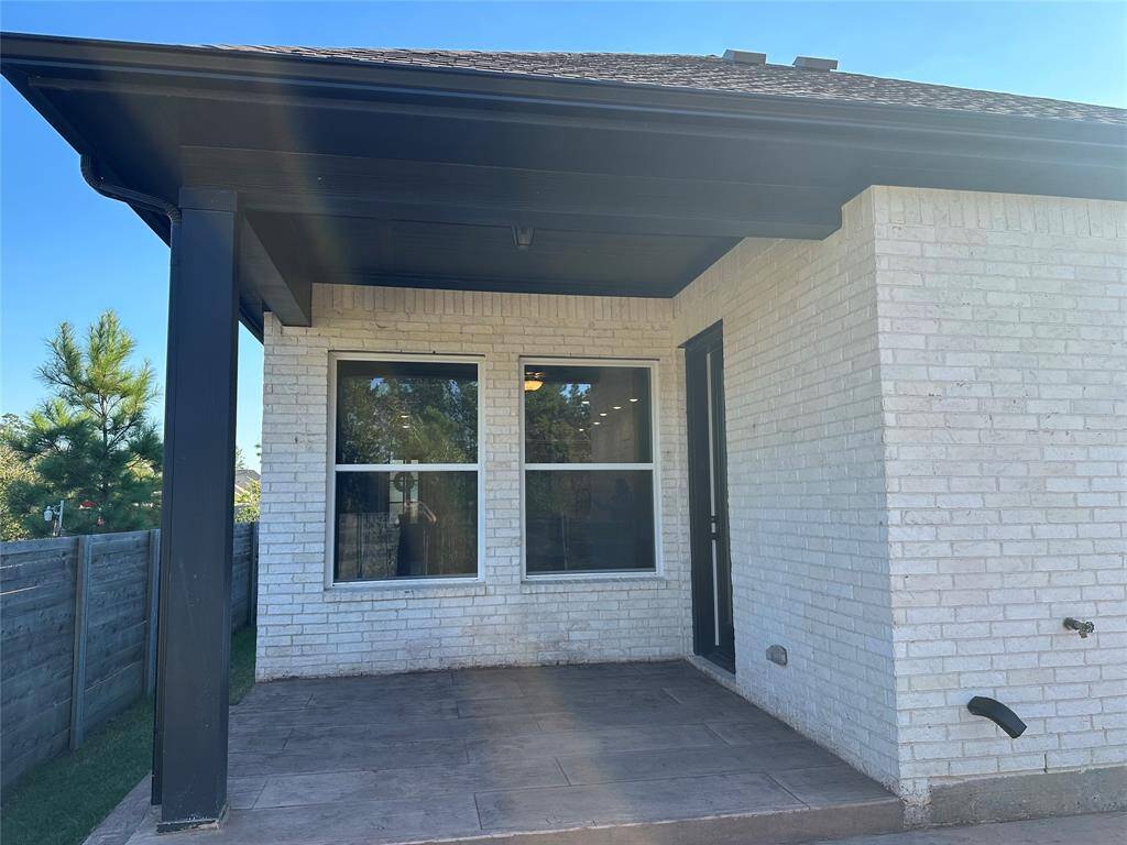 large covered patio with sprinkler system in front and back yard