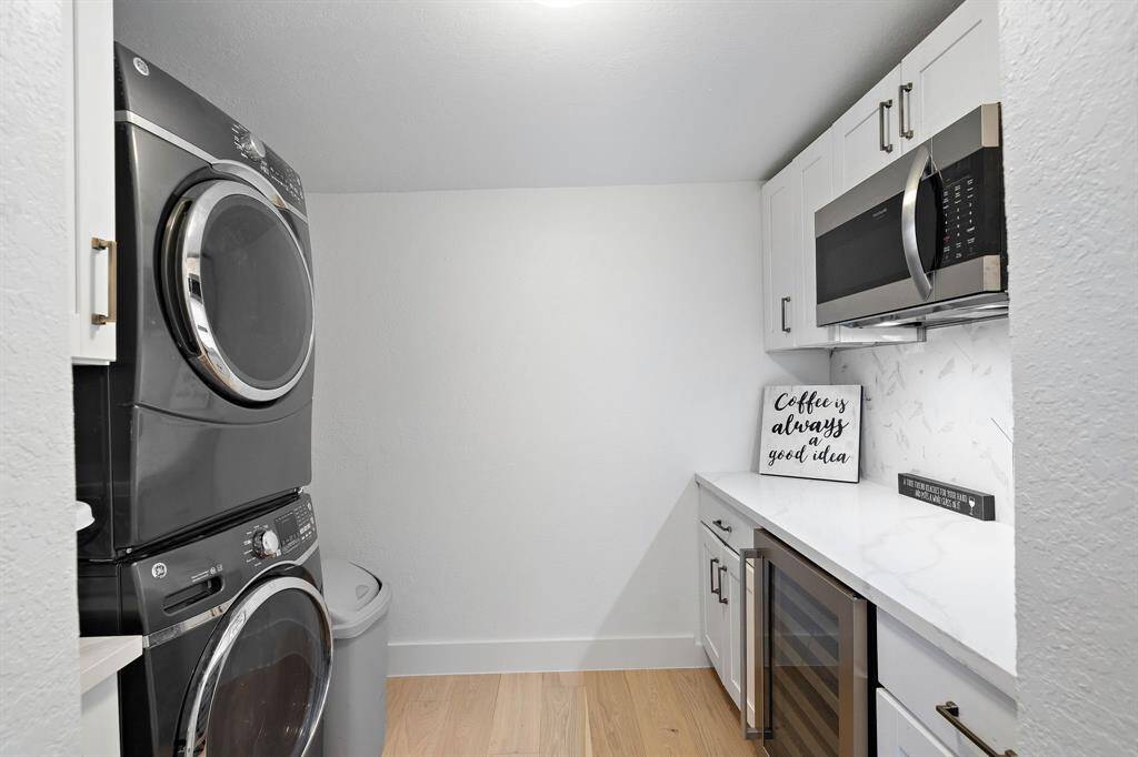 This butler's panty/utility room offers a coffee bar, wine refrigerator, and microwave, and comes with a full sized stackable washer and dryer.