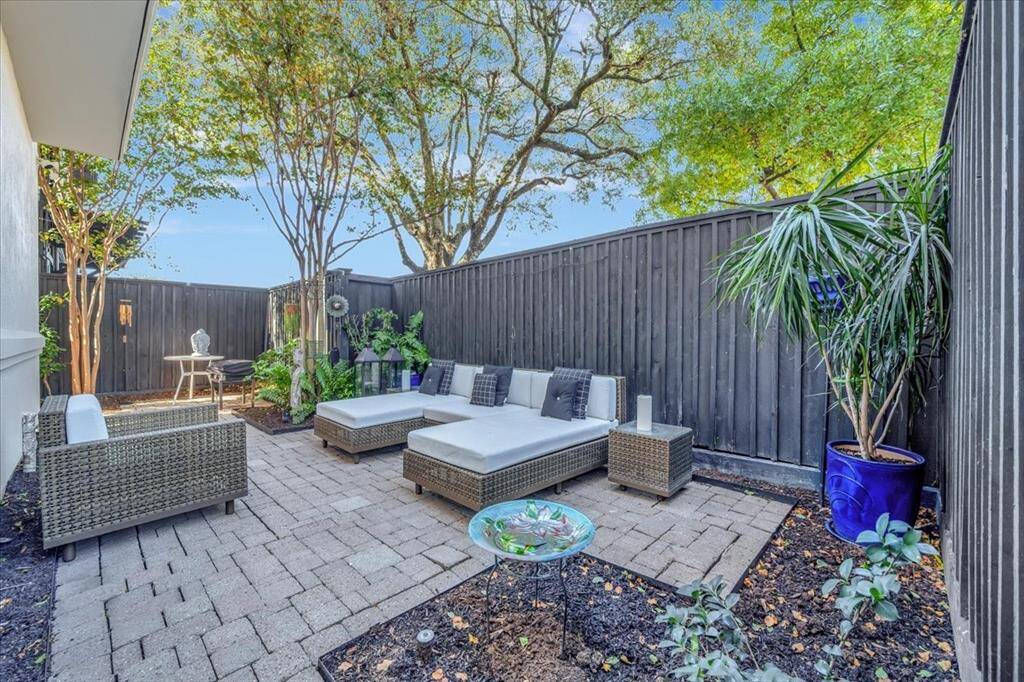 This home features a charming paved garden area on the side, offering plenty of space for seating and outdoor enjoyment, perfect for entertaining!