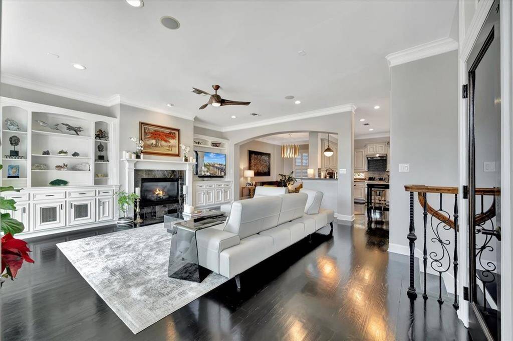 This view highlights a cozy gas log fireplace, beautifully flanked by built-in shelves and cabinets that provide ample storage options