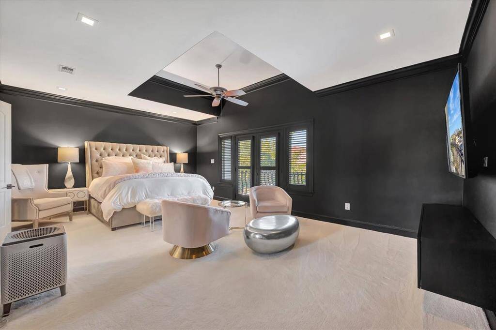 This oversized primary suite is a tranquil retreat, with bold black walls that set the tone for restful sleep. Double doors lead into the spa-like ensuite, while French doors open to the exterior balcony, offering a seamless connection to the outdoors.