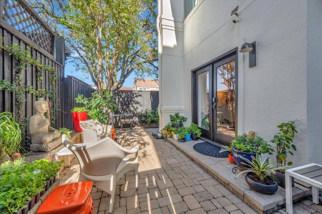 The exterior garden boasts a wrap-around paved design with ample seating space, complemented by a separate gated area discreetly housing outdoor components such as the air conditioning unit and generator.
