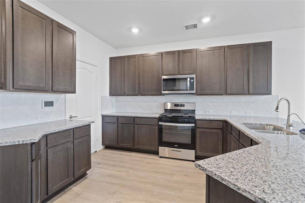 Additional view of this beautiful kitchen! Showcasing the gorgeous cabinetry, granite countertops with double bowl stainless steel sink and Moen PullDown Faucet!