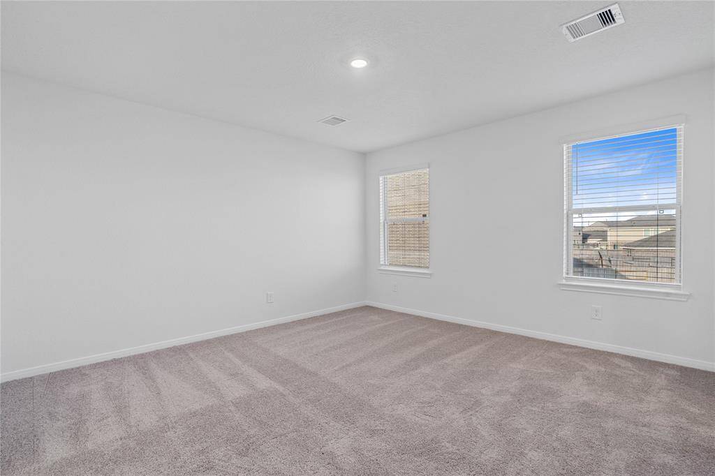 Come and unwind after a long day in this magnificent primary suite! This spacious room features plush carpet, warm paint, recessed lighting, high ceilings, and large windows with blinds allowing in natural light!