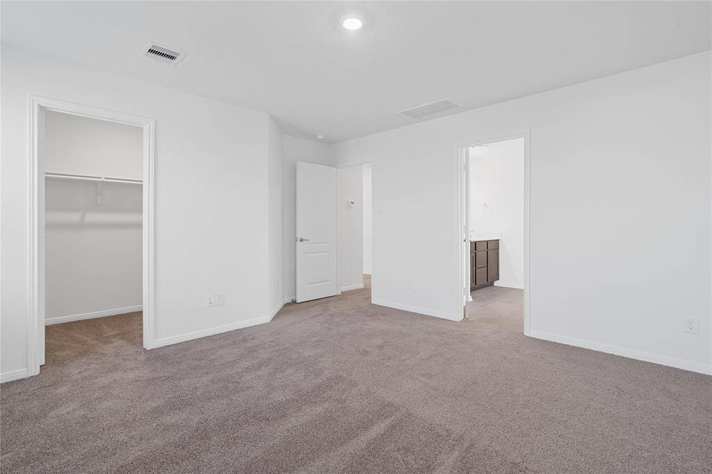 Additional primary bedroom views of the walk-in closet and en-suite primary bathroom.