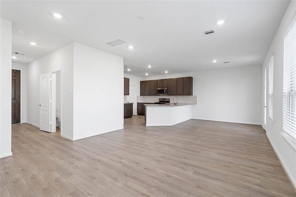 The open concept living, dining and kitchen makes for a great way to keep the party going and never miss a beat! Gather the family together in good conversation while preparing a fabulous meal. This Great Room features large windows with blinds, high ceilings, recessed lighting, and Layton Lake vinyl plank flooring in Soft Beige!