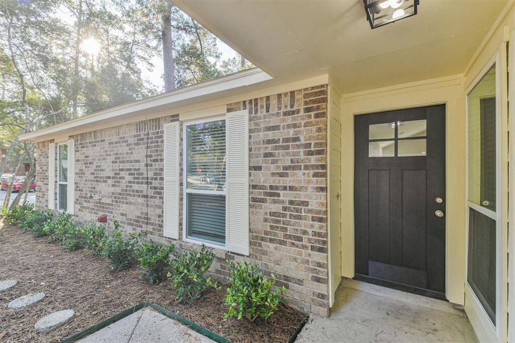 Beautiful solid wood front door with covered entry for staying out of the rain.