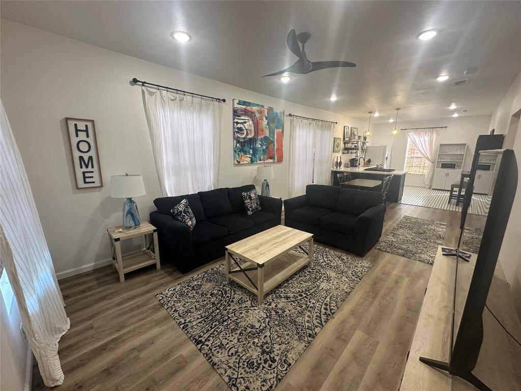 The additional view of your living room features gorgeous flooring, high ceilings, recessed lighting, and ceiling fan. Perfect for entertaining family and guests.