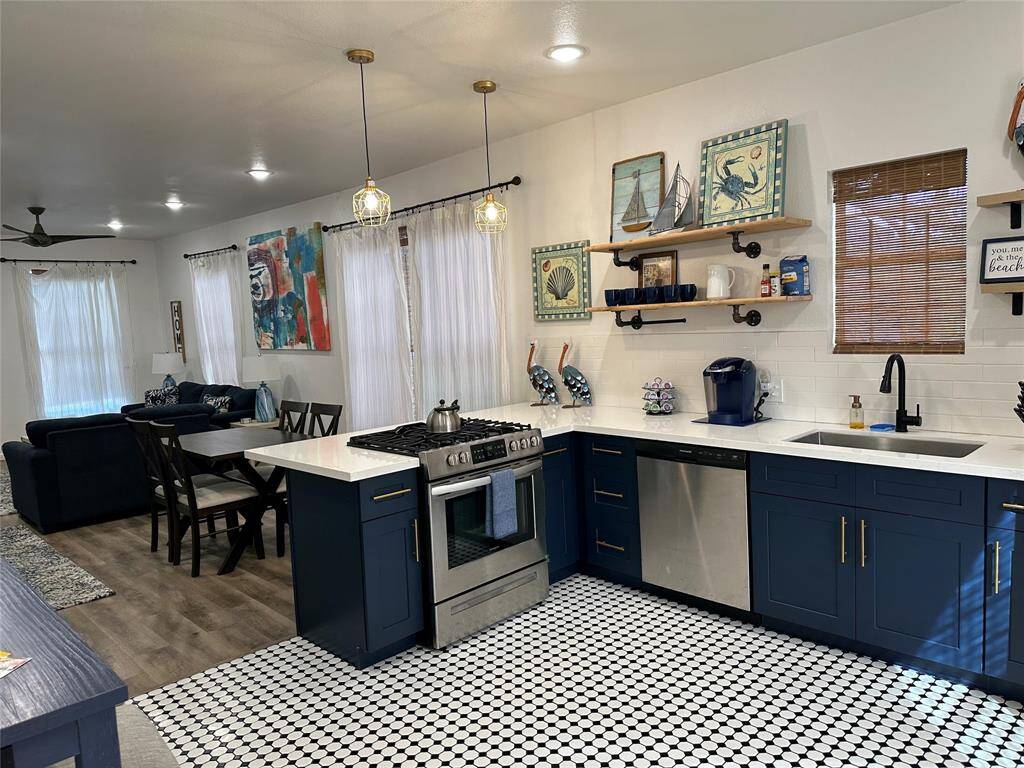 This kitchen is by far any chef's dream! This spacious kitchen features high ceilings, navy blue stained wood cabinets, quartz countertops, SS appliances, modern tile backsplash, recessed lighting, extended counter space with space for breakfast bar overlooking your huge family room.