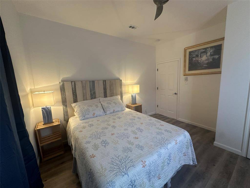 Secondary bedroom features gorgeous flooring, high ceilings, custom paint, and a large window with natural light.