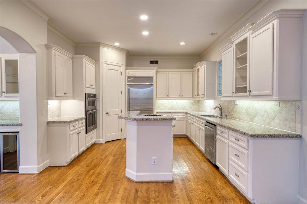 This luxury kitchen features pristine white cabinetry that creates a sleek and timeless aesthetic, paired perfectly with stunning granite countertops for a sophisticated and durable surface. Equipped with state-of-the-art stainless steel appliances, this space offers both style and functionality, ideal for gourmet cooking and seamless entertaining. Whether preparing a meal or hosting guests, this kitchen is designed to impress, combining elegance with the highest level of convenience and modern luxury.