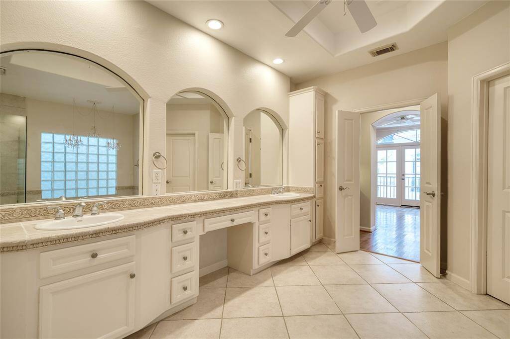 another view of the primary bathroom with dual sinks and elegant finishes.