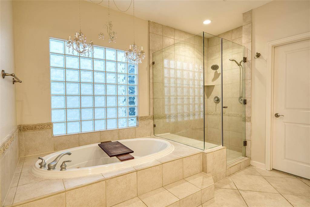 Indulge in luxury with a jetted soaking tub and sleek frameless shower.