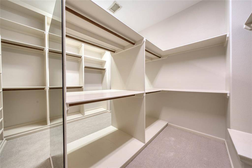 Expansive custom walk-in closet with built-in shelving for optimal organization.