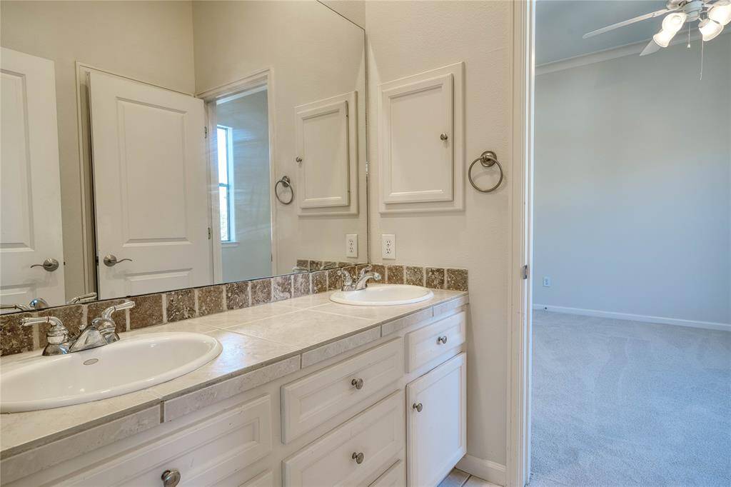 Spacious ensuite full bathroom featuring elegant double vanities.