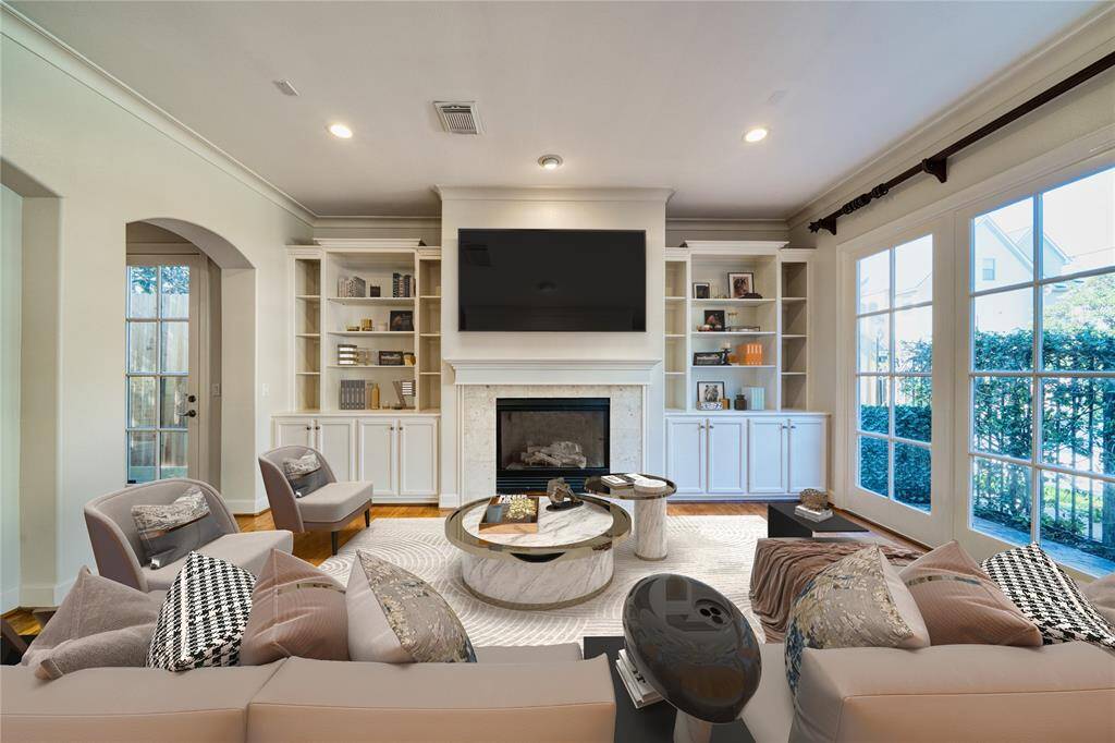 Bright and airy living room featuring a built-in entertainment center and a cozy gas fireplace. Abundant natural light flows throughout the entire space, creating a warm and inviting atmosphere for family and friends
