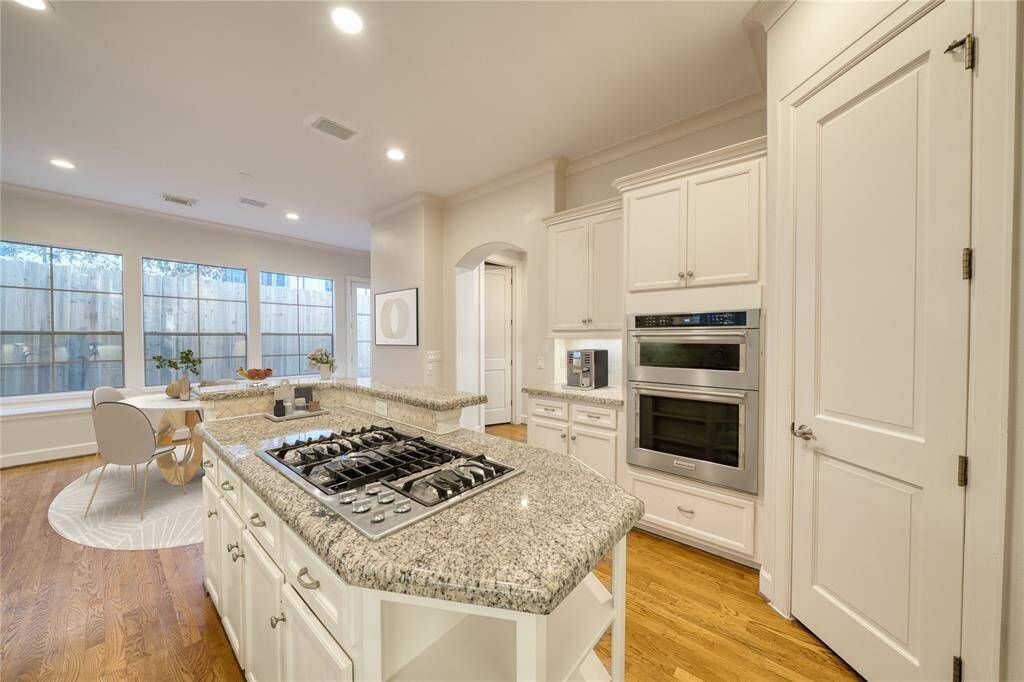 A sleek gas cooktop with a built-in center island offers both functionality and style, while providing stunning views of the entire kitchen, making it the perfect space for cooking and entertaining.