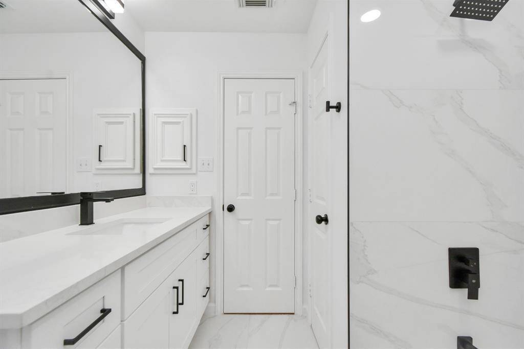 The spacious En-Suite Bathroom also offers a great amount of storage, sleek ebony fixtures, lighting and hardware - along with crisp and clean white quartz counter tops.