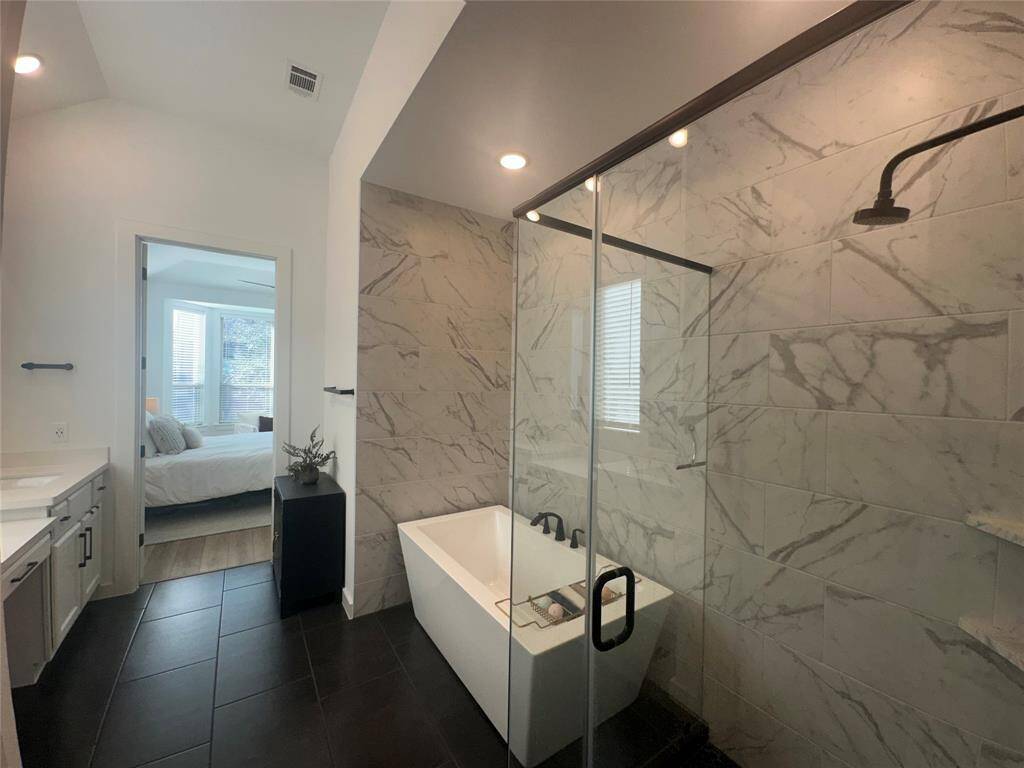 Grab the bubble bath, put on some music, and enjoy a wonderful evening in your amazing spa like garden bath soaking tub! Featuring tile flooring, neutral paint, tile surround and separate spa like spacious walk-in shower, making this the perfect bathroom for relaxing.