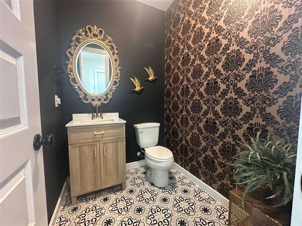 The stylish half bathroom offers both convenience and charm. Featuring modern finishes, and elegant finishes, it's the perfect blend of design and functionality. Ideal for guests, this well-appointed space adds a touch of sophistication to your home.