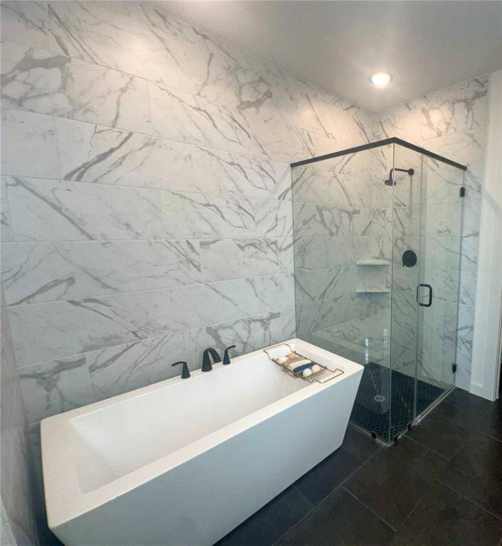 This additional view of the primary bath showcases the spacious walk-in shower with tile surround and a separate garden spa like tub perfect for soaking after a long day.