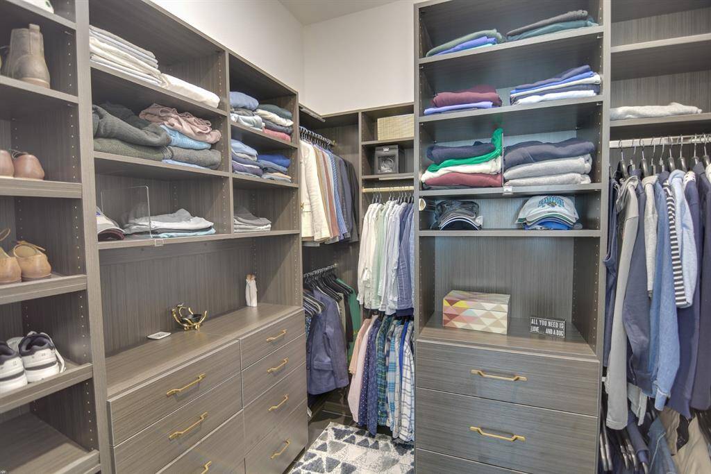 Step into your spacious walk-in closet with custom shelving and built-ins.