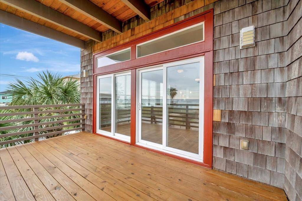 A balcony adorned with cedar shaker shingles and equipped with high-performance sliding glass doors.