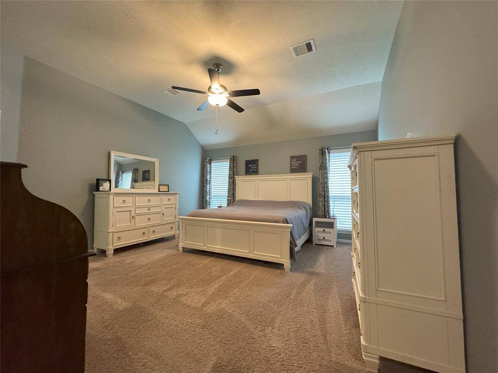 Spacious primary bedroom with ceiling fan.