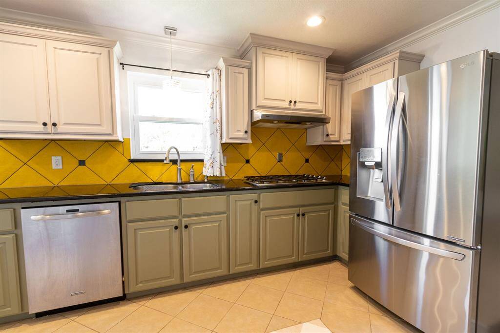 Dishwasher, double sink, gas stove top and refrigerator.