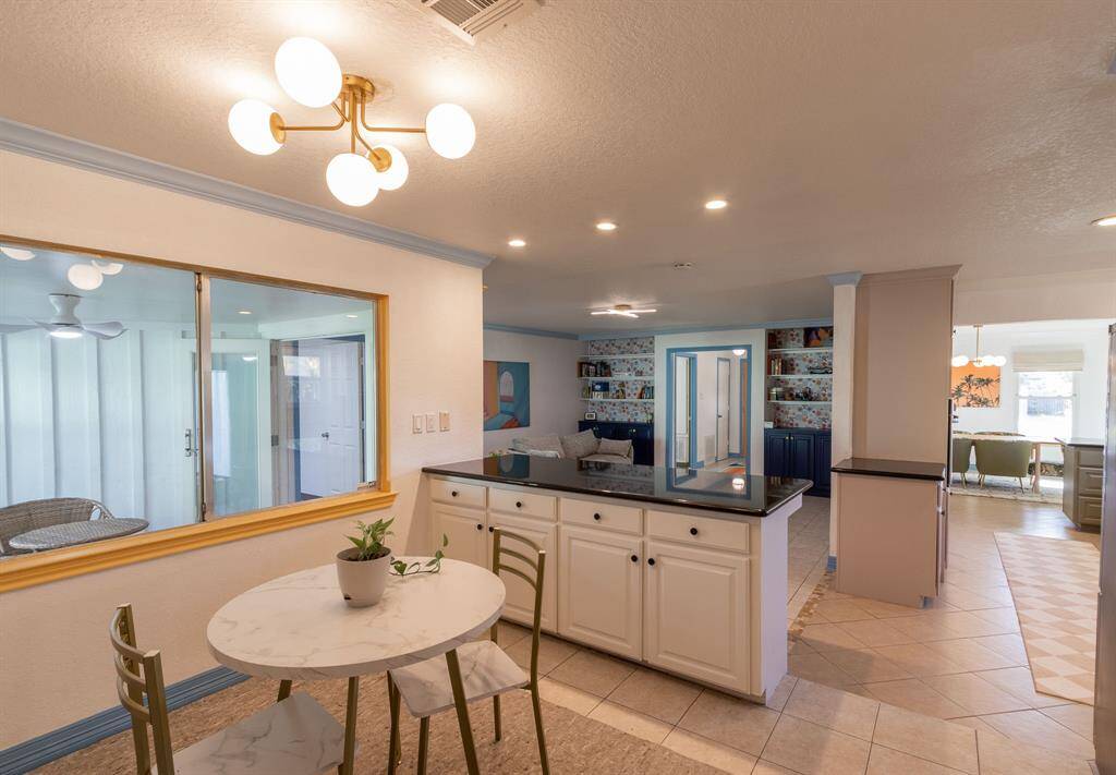 Breakfast area looking through the kitchen to the right and the living room to the left. Sunroom through the windows to the left.