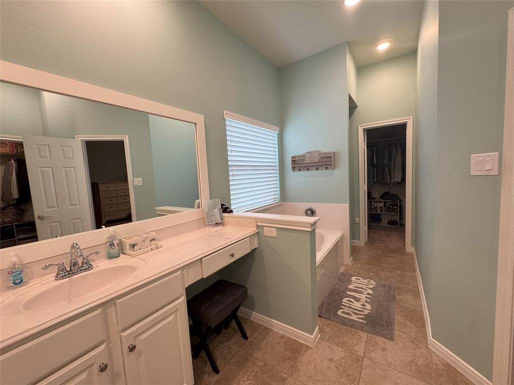 Primary bathroom with dual vanities and soaker tub.
