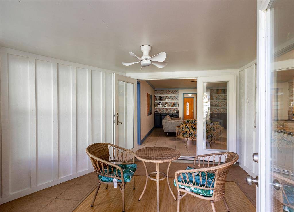 Looking through the backdoors through the sunroom & glass French doors into the living room.