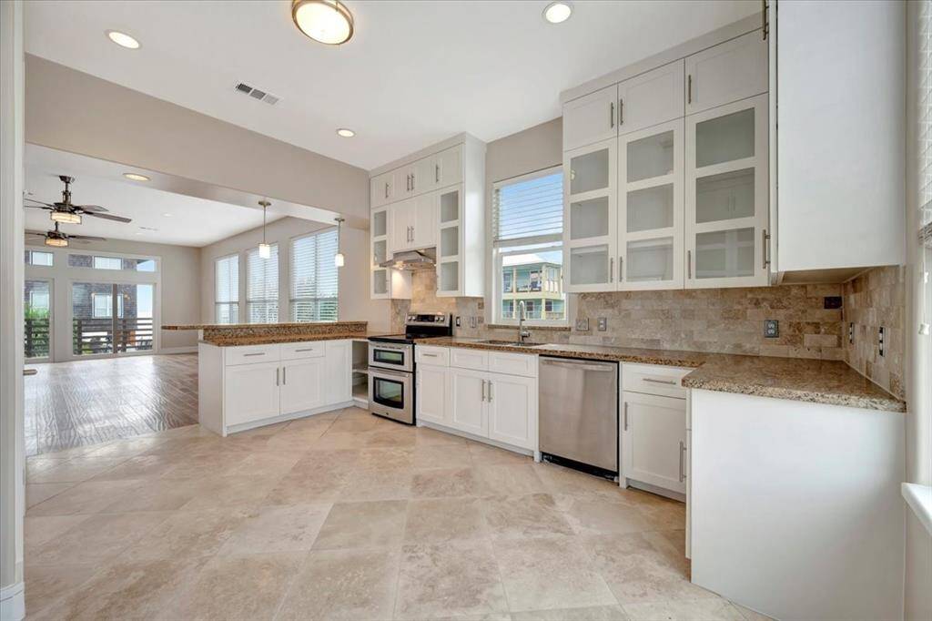 A bright and airy kitchen with windows adorning most walls, flooding the space with natural light and providing picturesque views from every angle