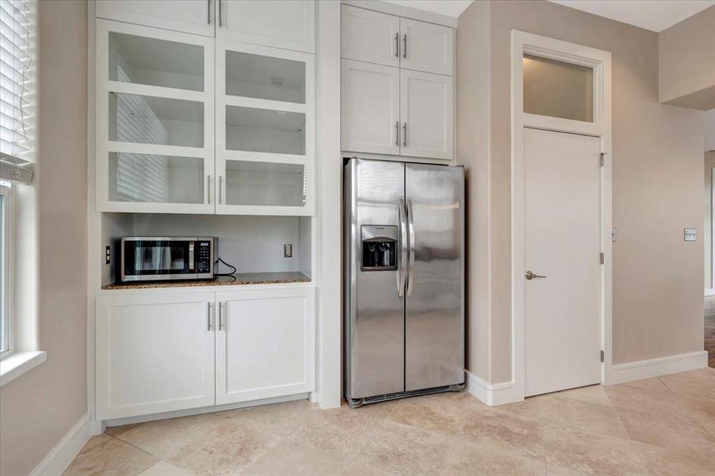 A compact butler's pantry enhances functionality with glass-front cabinets for a touch of elegance and additional counter space for convenient meal prep or storage.