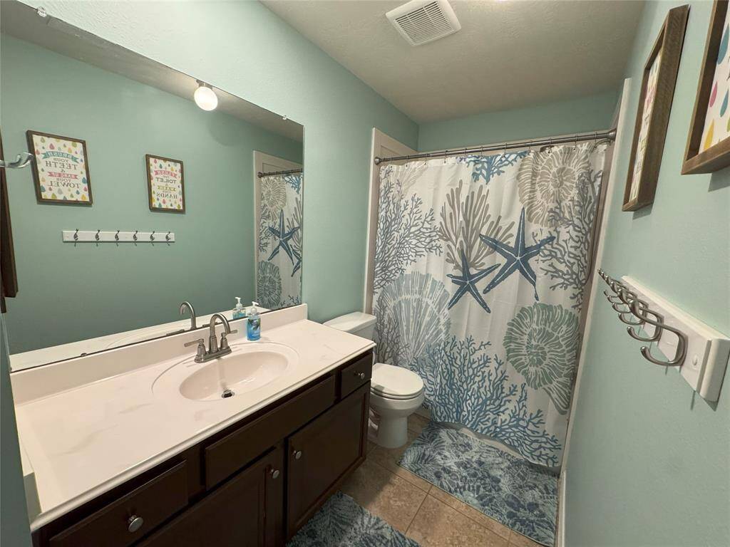 Secondary bathroom off the hallway by the second and third bedrooms.