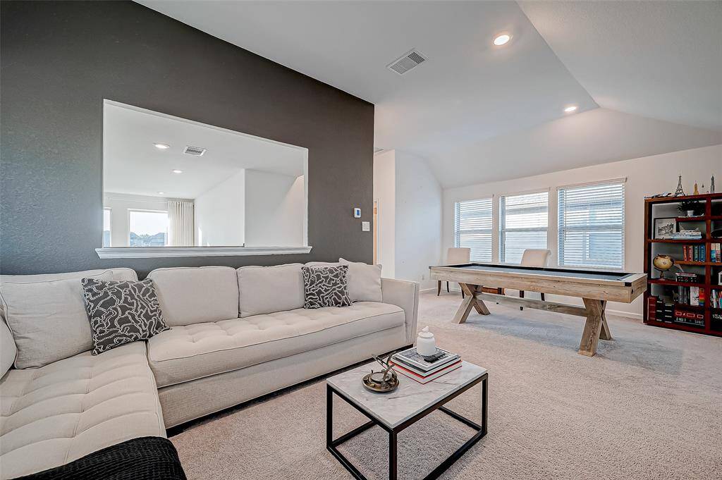 The game room features large window overlooking the first floor living area.