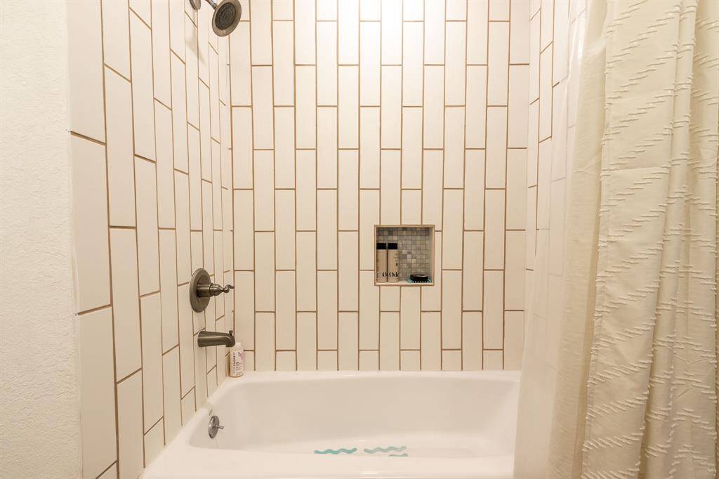 Bathtub with shower in the hall bath.