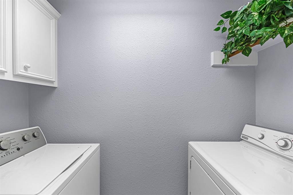 The in-home laundry room has cabinets and shelving. It also features a convenient hanging rod to make laundry a little easier. Washer and dryer stay with the home!