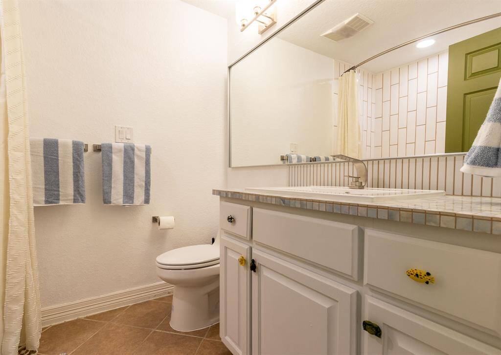 Hall bath with tiled shower stall.