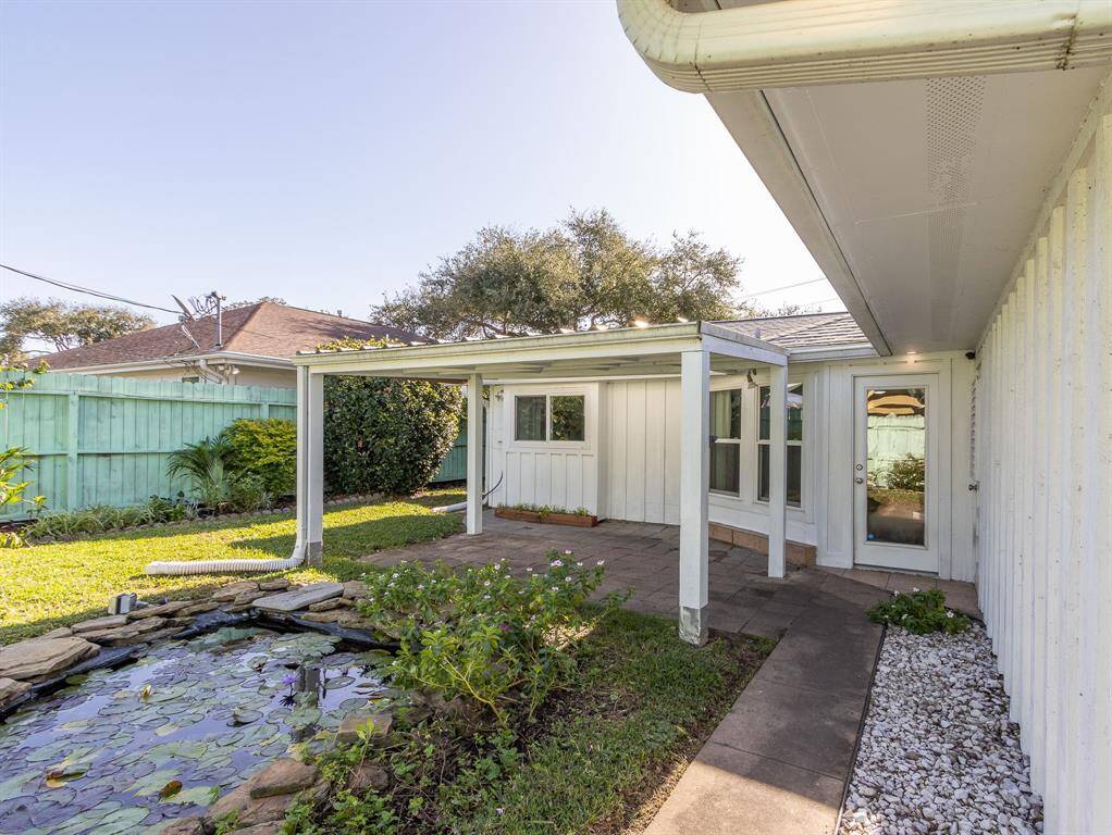 Backyard with koi pond to the right. Sunroom doorway in background.
