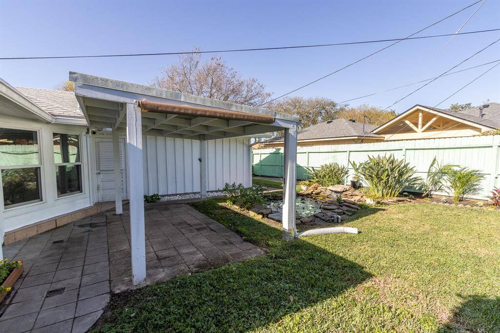 Backyard picture with covered patio and water feature.