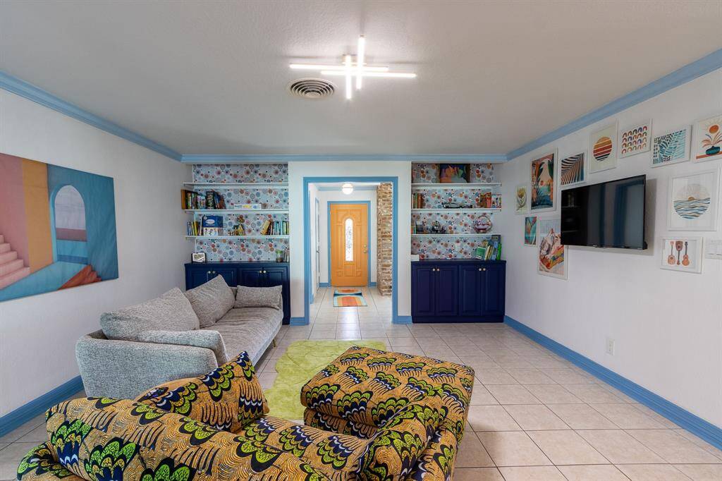 Looking through the living room to the front door and front foyer area. Bookshelves on either side of the doorway.