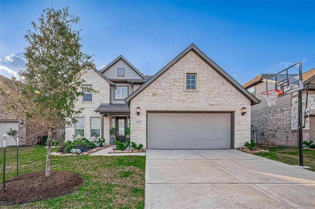 This is a modern two-story stone and brick home with a two-car garage, a neatly landscaped front yard, and a basketball hoop. Built by Lennar builders Fairway collection Wakefield Floor Plan.