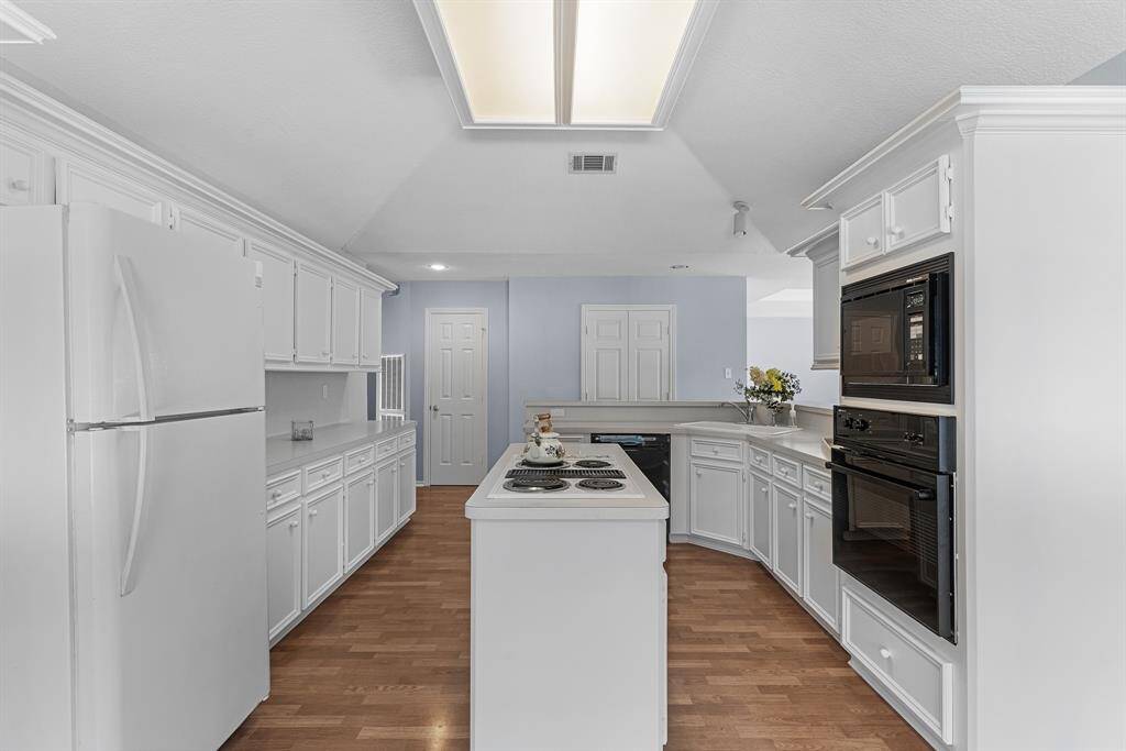 The high ceilings and natural light make this kitchen feel open and airy. The double doors at the end of the kitchen lead to the in-home laundry. The washer and dryer convey with the home.