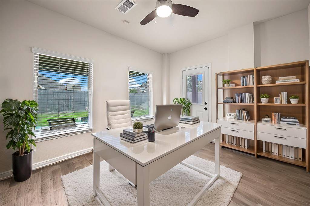 Versatile sunroom at rear of home could be used as a flex room, home office, playroom, music room, etc. The possibilities are endless! (Virtually staged)