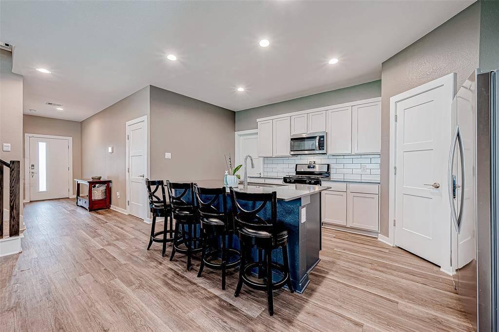 Stylish kitchen with modern appliances and a clear view towards the inviting front entrance.