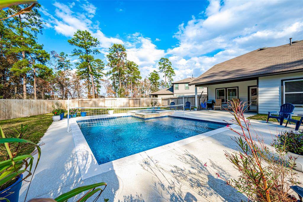 Luxurious sports pool with a sun deck and hot tub featuring app-controlled heated water and LED lighting for ultimate relaxation.