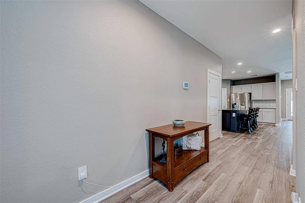 Step through the front door into a bright, open space that seamlessly connects the modern kitchen and family room, with the first of five bedrooms conveniently located near the front.